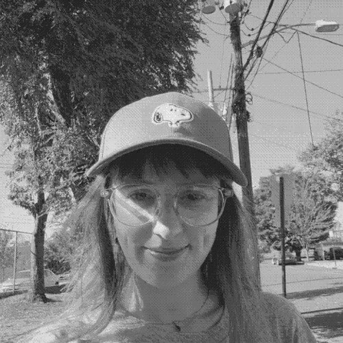 A woman in a cap smiles.