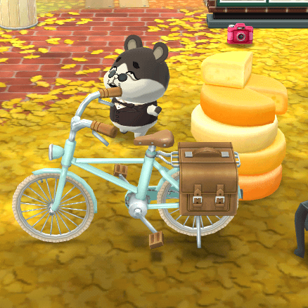 A hamster villager stands near a bicycle and a large pile of cheese.